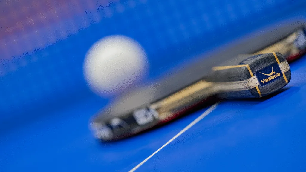 Bild på ett racket och boll på ett bordtennis